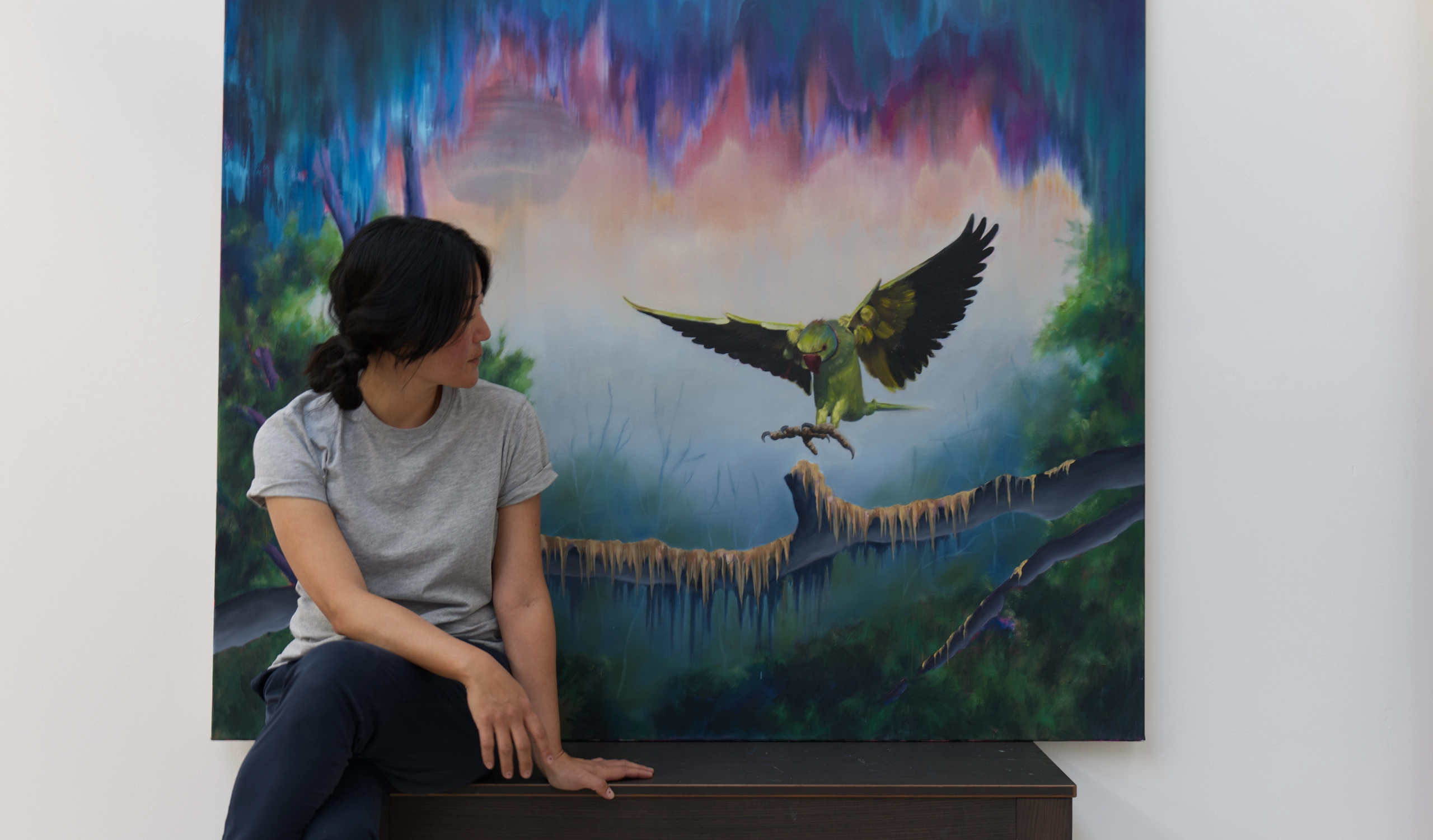 You-Jin Chang with oil painting of a green parrot